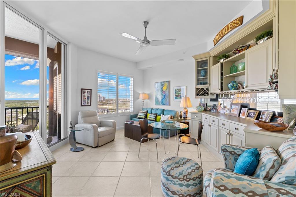 Living area featuring light tile patterned floors and a ceiling fan