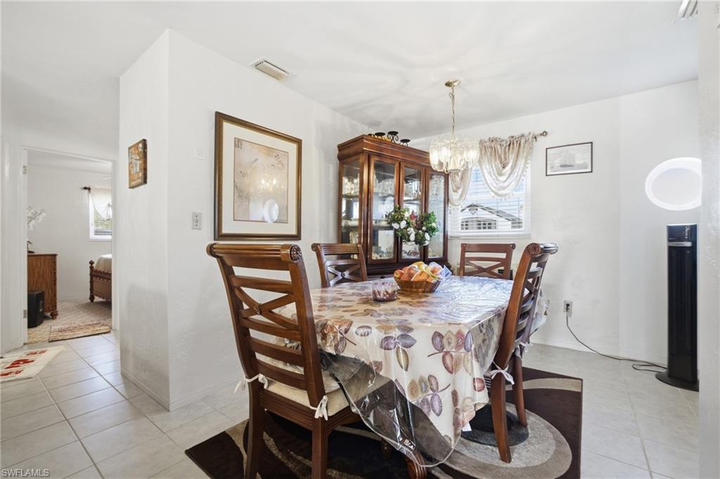 Dining area featuring light tile patterned floors and a chandelier