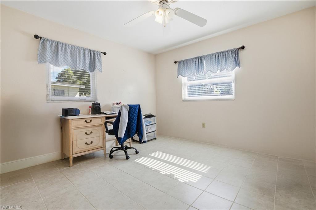 Office area featuring light tile patterned floors and a ceiling fan