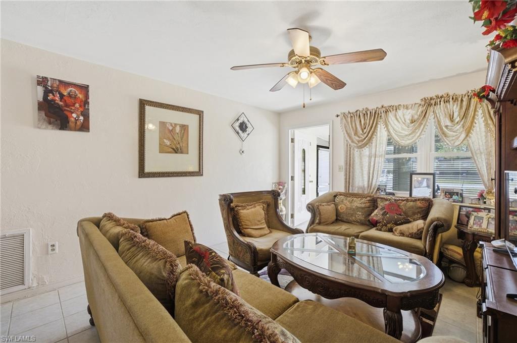 Living area with tile patterned flooring and ceiling fan