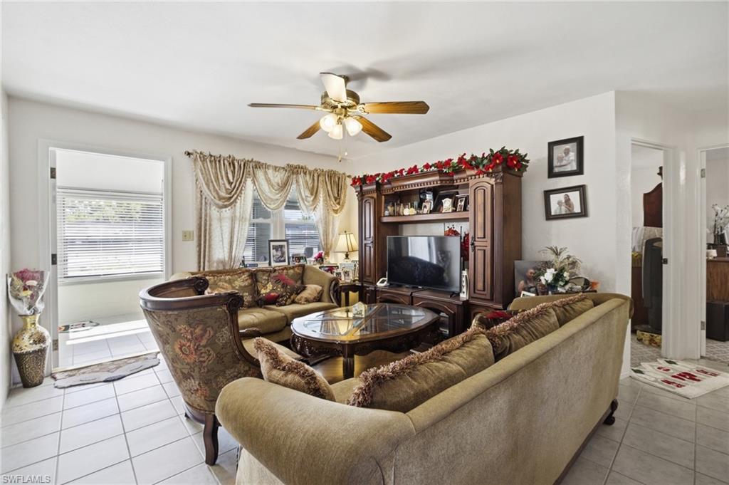 Living area featuring ceiling fan and light tile patterned floors