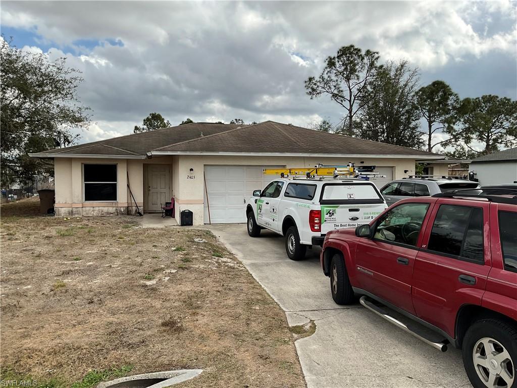 View of front facade featuring roof with shingles, a garage, stucco siding, and concrete driveway