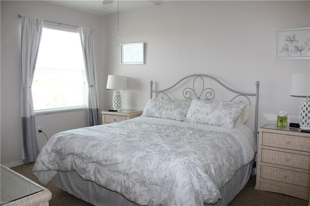 Carpeted bedroom featuring a ceiling fan