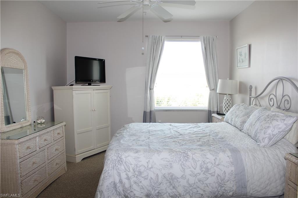 Bedroom featuring dark carpet and a ceiling fan