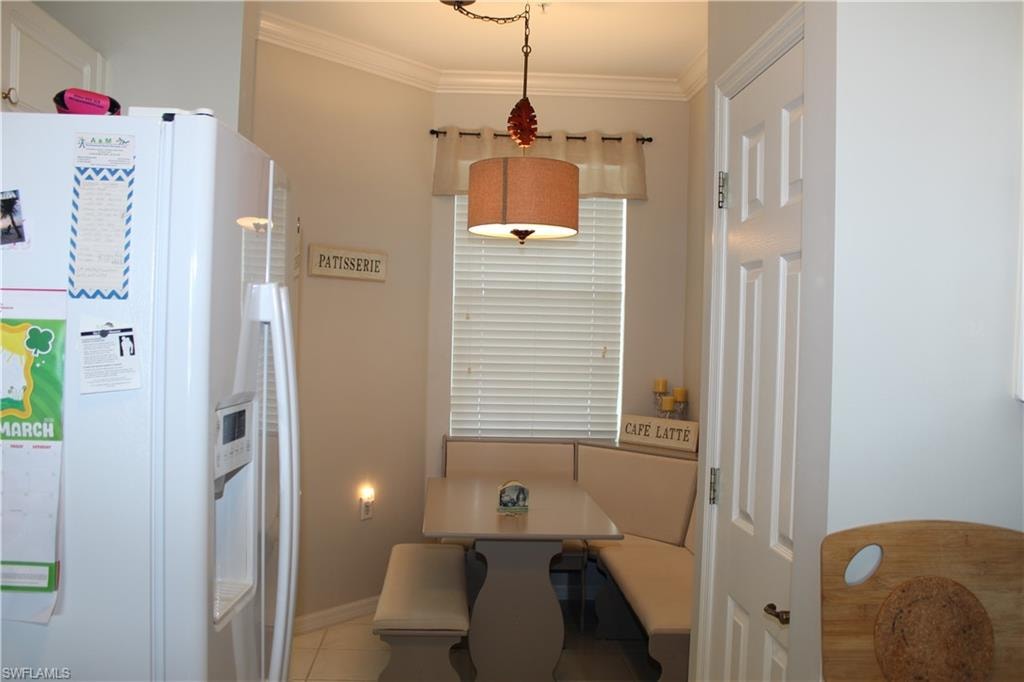 Dining area featuring ornamental molding and light tile patterned floors