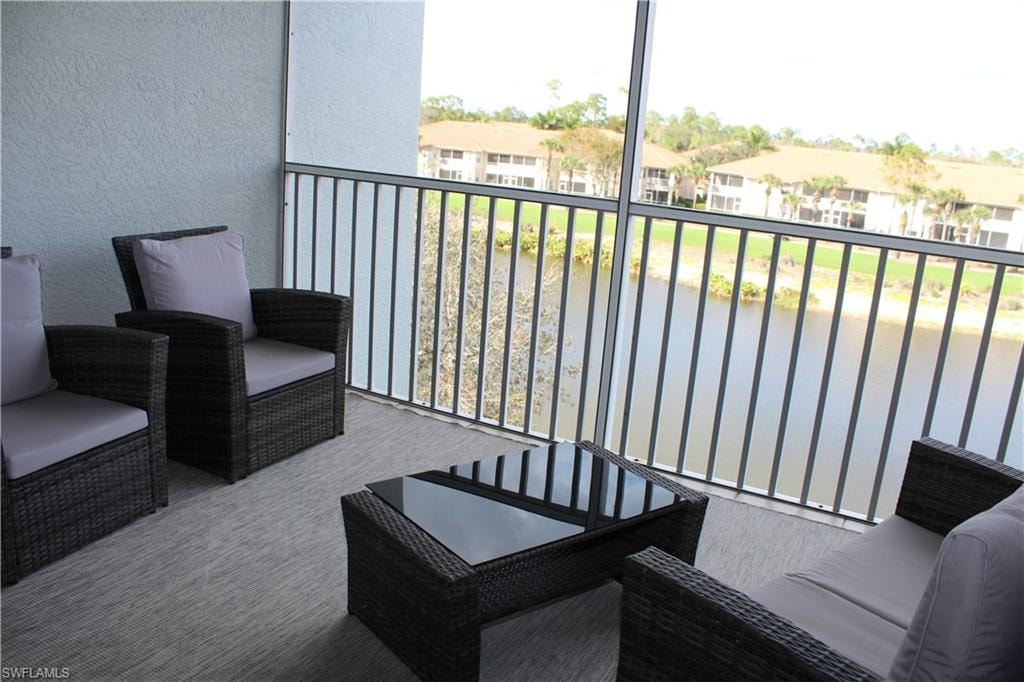 Balcony featuring a sunroom and a water view