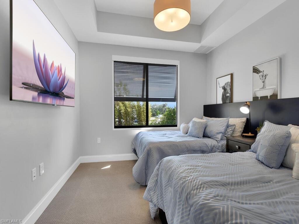 Bedroom featuring carpet and a tray ceiling