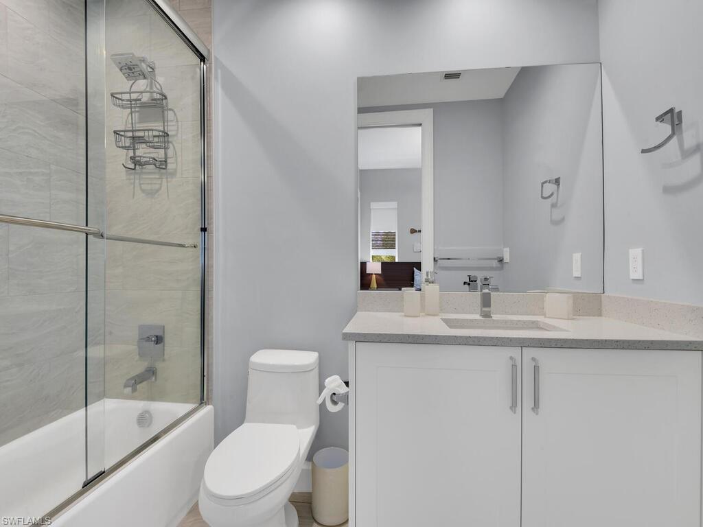 Full bathroom with vanity and combined bath / shower with glass door