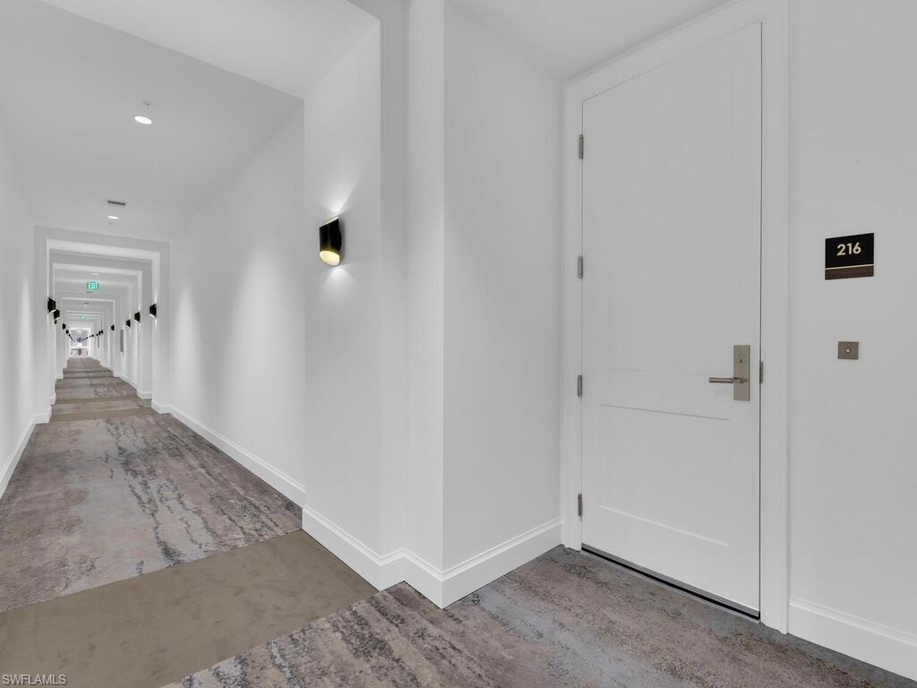 Hallway featuring baseboards and concrete flooring