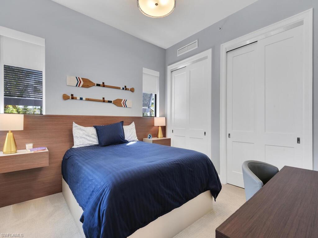 Carpeted bedroom featuring a closet and an office area