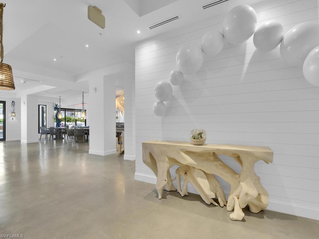 Corridor featuring finished concrete floors, recessed lighting, and wooden walls