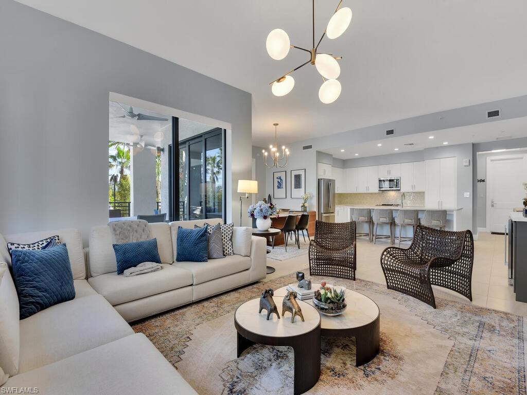 Living area featuring a chandelier, ceiling fan, and light tile patterned floors