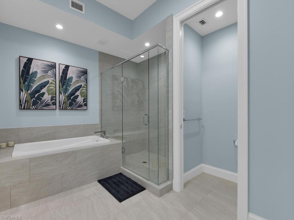 Full bath with a shower stall, a bath, light tile patterned floors, and recessed lighting