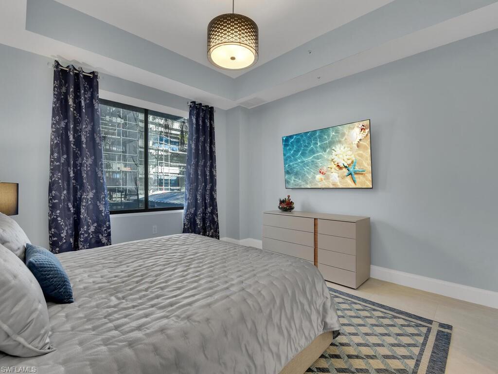 Bedroom featuring light tile patterned floors and a raised ceiling