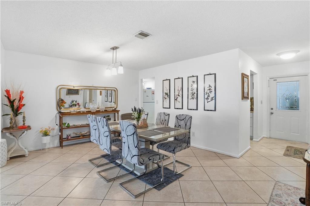 Dining space featuring light tile patterned floors and a textured ceiling
