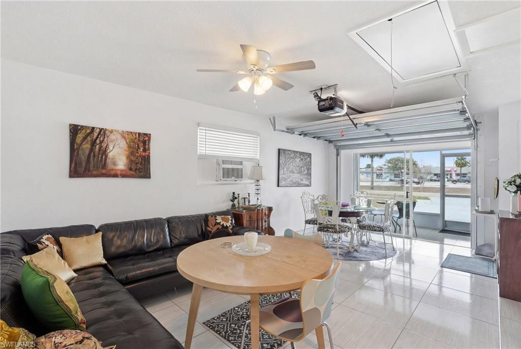 Living area featuring ceiling fan, light tile patterned floors, and cooling unit