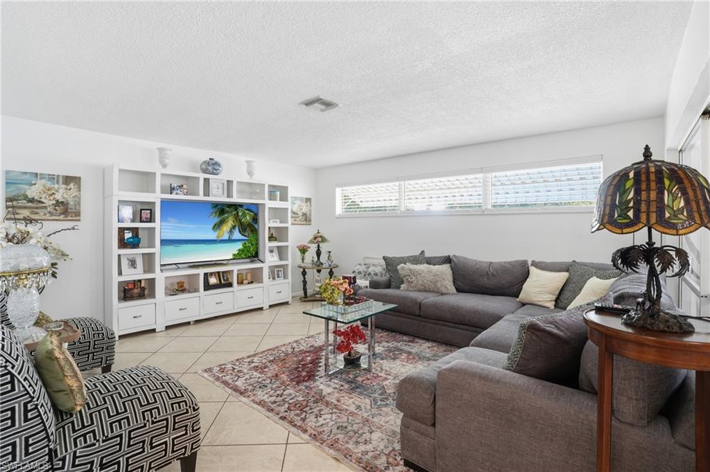 Living area with light tile patterned floors and a textured ceiling