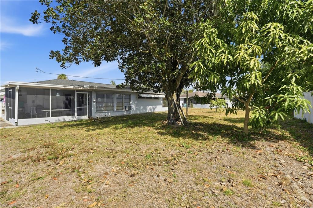 Rear view of property with a sunroom and a yard
