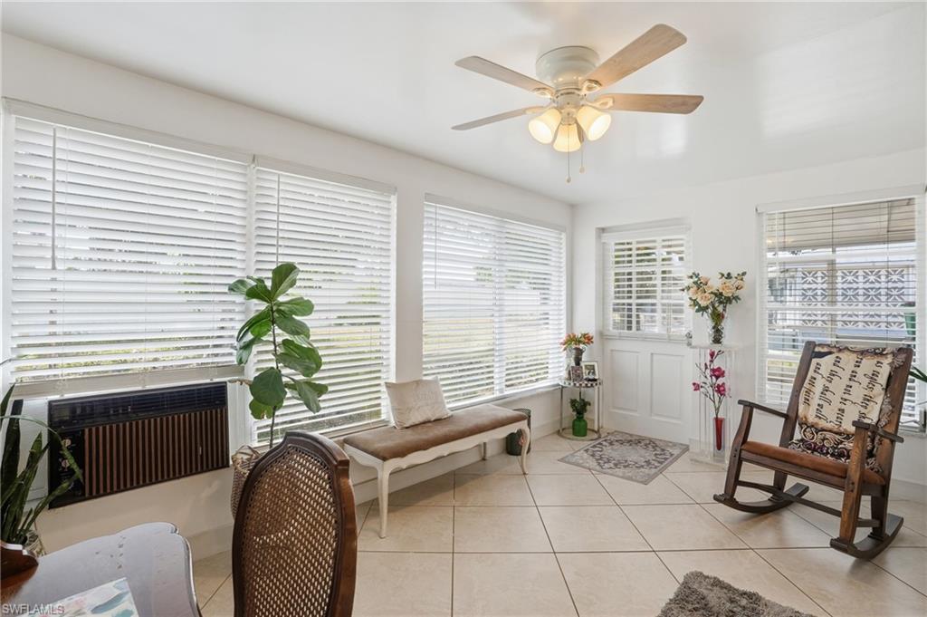 Living area featuring light tile patterned floors and a ceiling fan