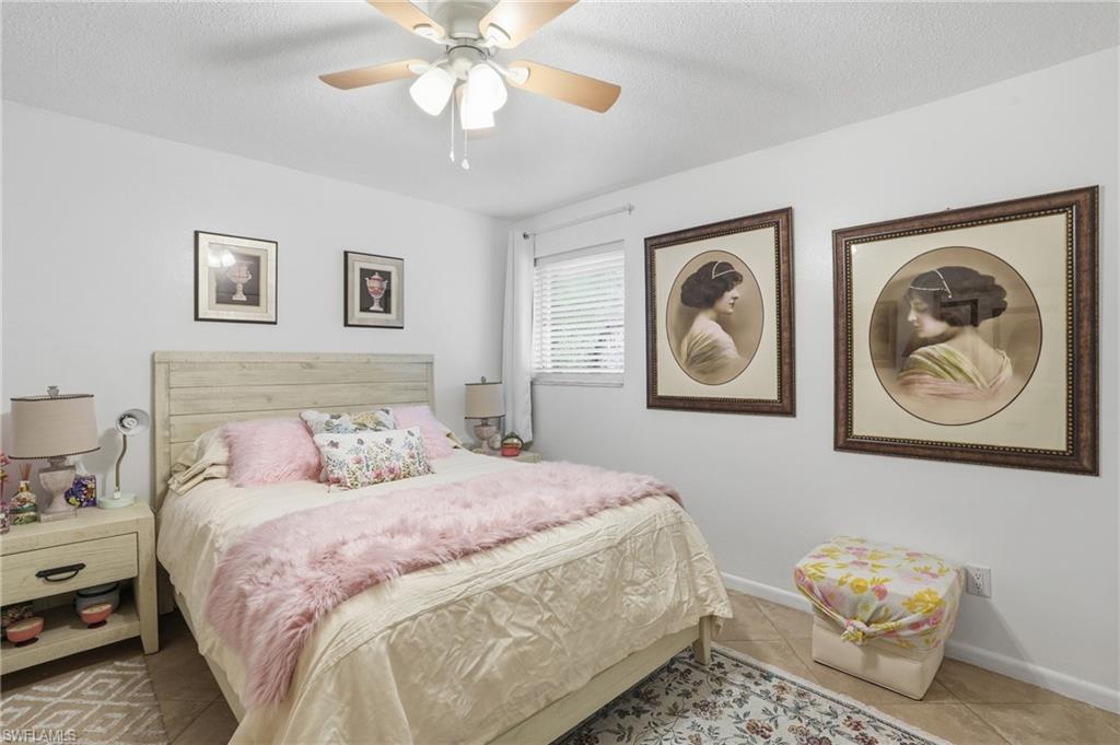 Bedroom featuring a textured ceiling, a ceiling fan, and tile patterned flooring