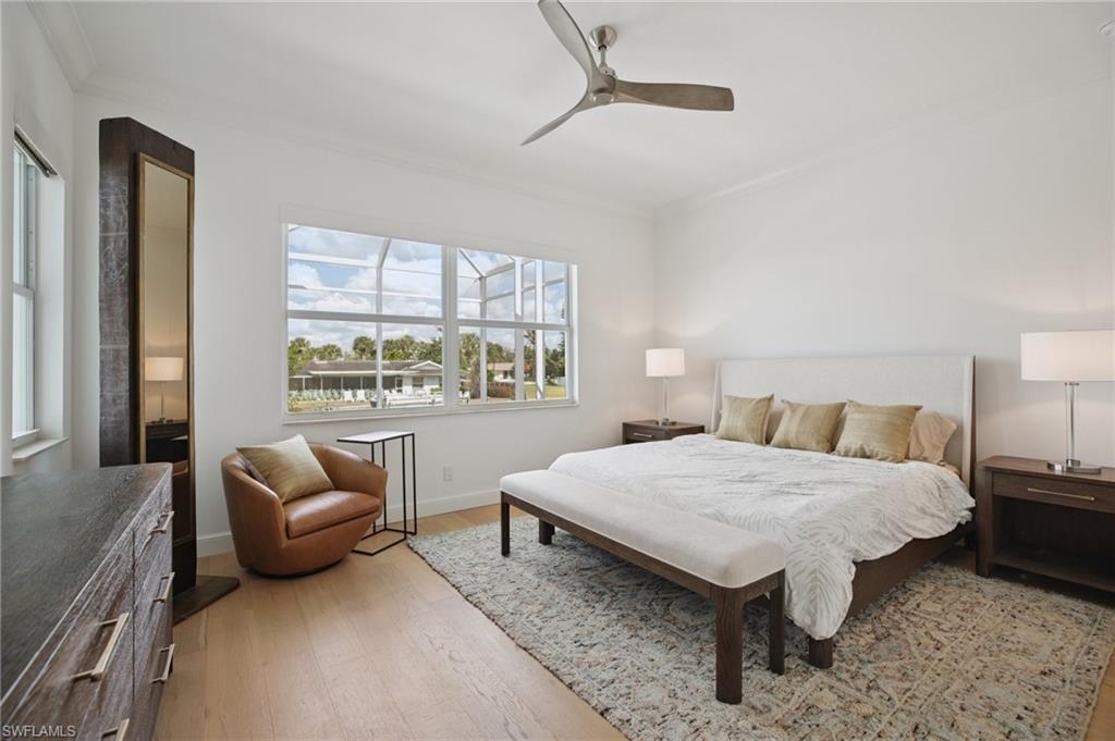 First floor bedroom with wood flooring, crown molding, and ceiling fan