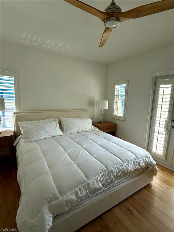 Upstairs bedroom with balcony and light wood tone wood-finish flooring