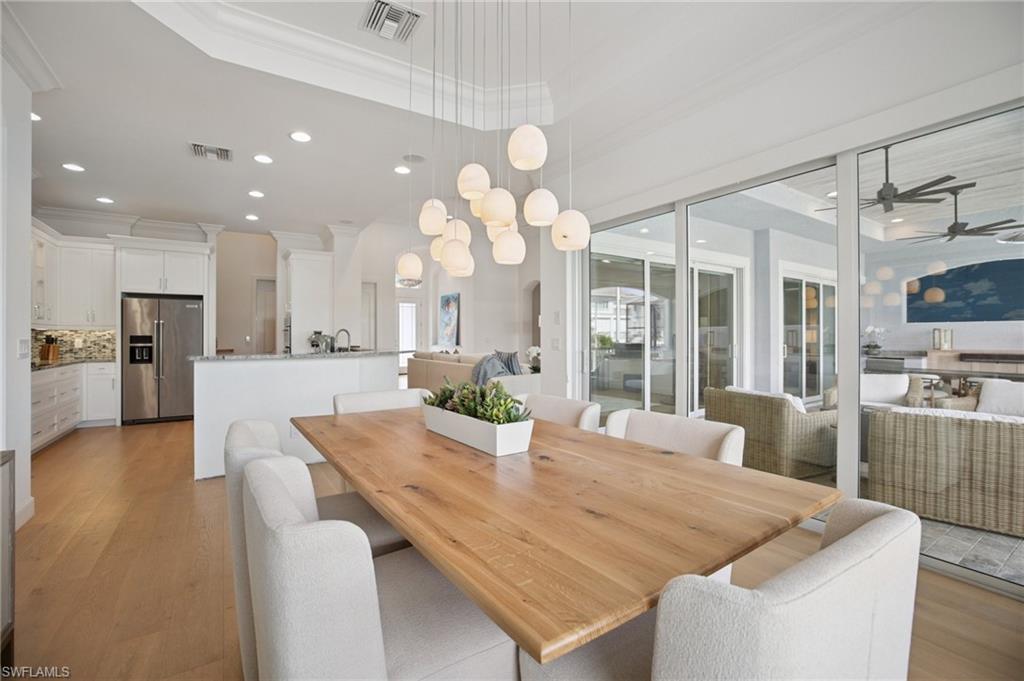 Dining area with crown molding, recessed tray ceiling and chandelier