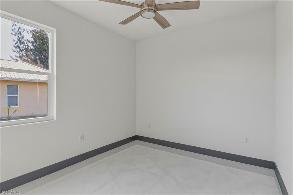Spare room with baseboards and a ceiling fan