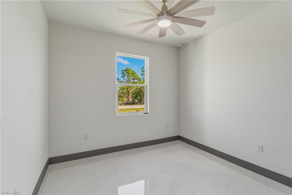 Unfurnished room featuring baseboards and ceiling fan
