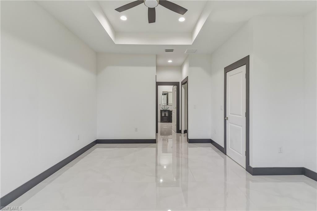 Spare room with recessed lighting, a raised ceiling, and ceiling fan