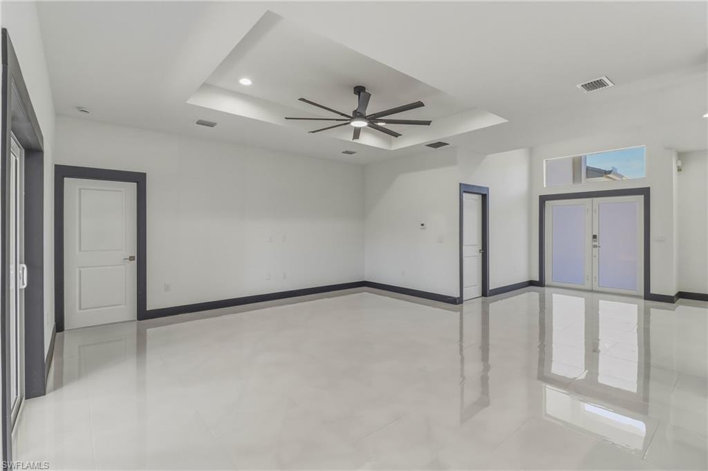 Unfurnished room featuring a tray ceiling, a ceiling fan, and recessed lighting