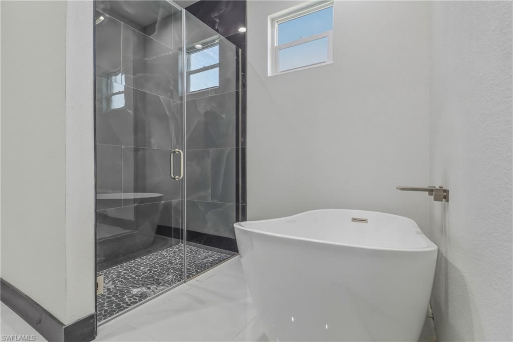 Bathroom with a stall shower and a soaking tub
