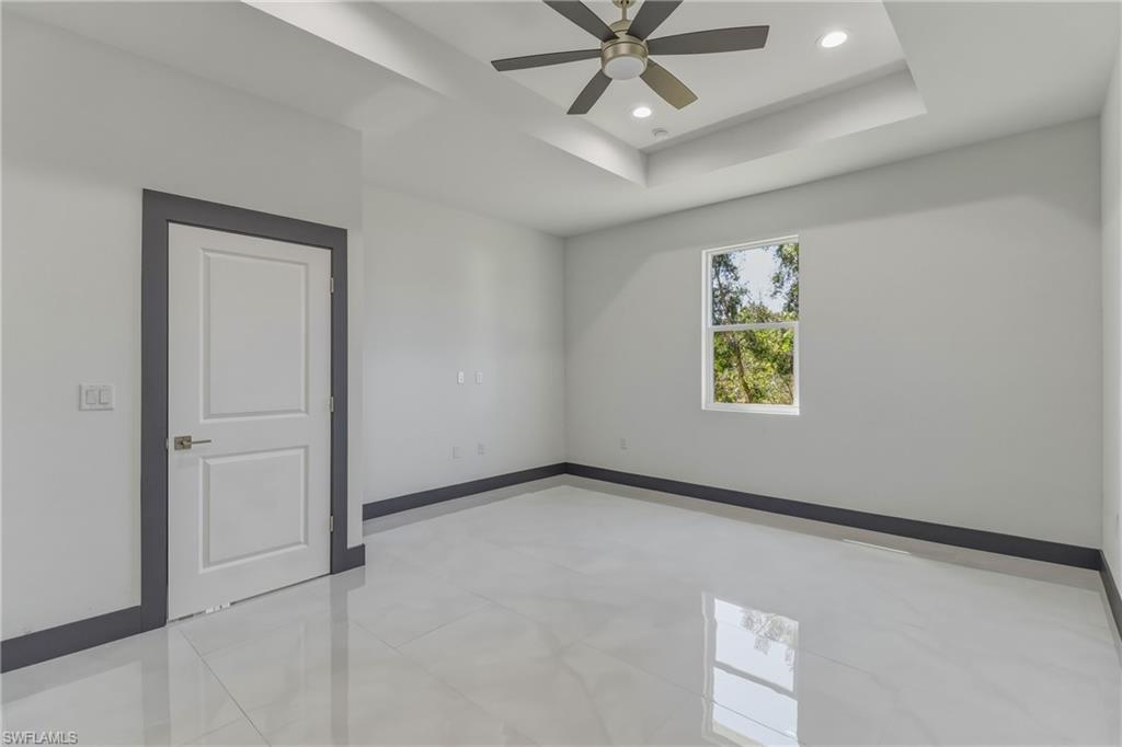 Unfurnished room featuring recessed lighting, a tray ceiling, and ceiling fan