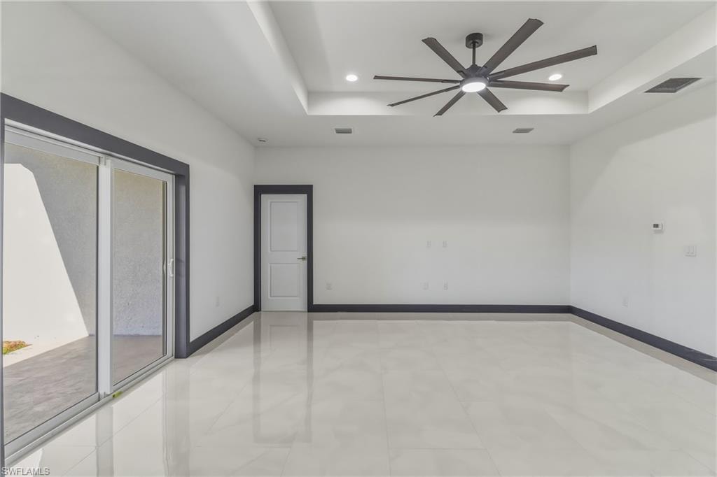 Unfurnished room with ceiling fan, a tray ceiling, and recessed lighting