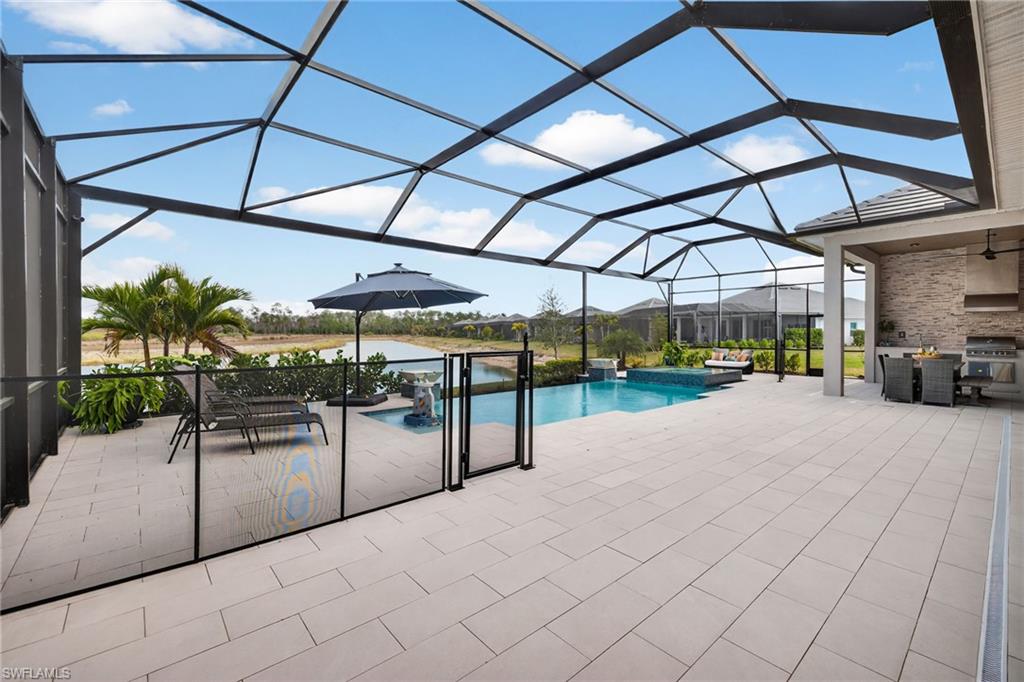 Outdoor pool with a sunroom, a patio, glass enclosure, and outdoor dining space