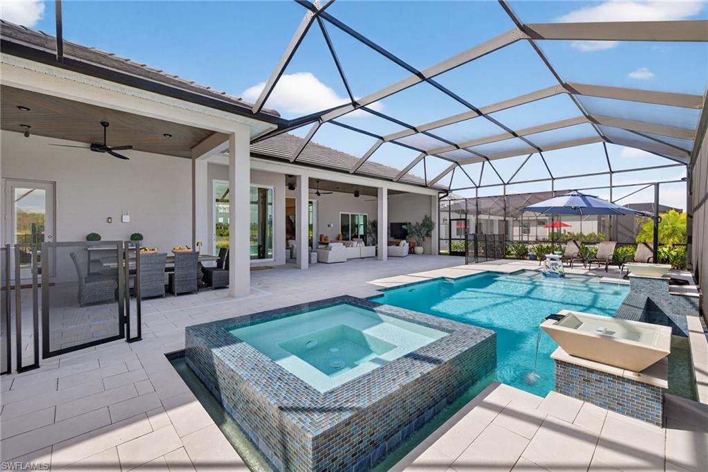 Combined pool / hot tub featuring a patio area, a sunroom, a lanai, and outdoor lounge area