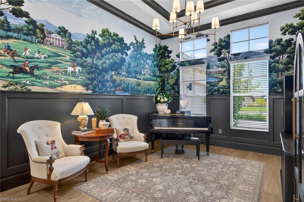 Sitting room featuring wood finished floors, suspended lighting, a decorative wall, and a high ceiling