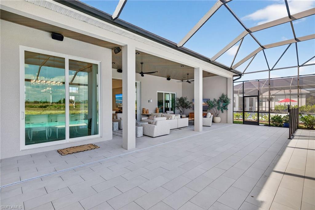 View of patio / terrace with a sunroom, glass enclosure, ceiling fan, and outdoor seating