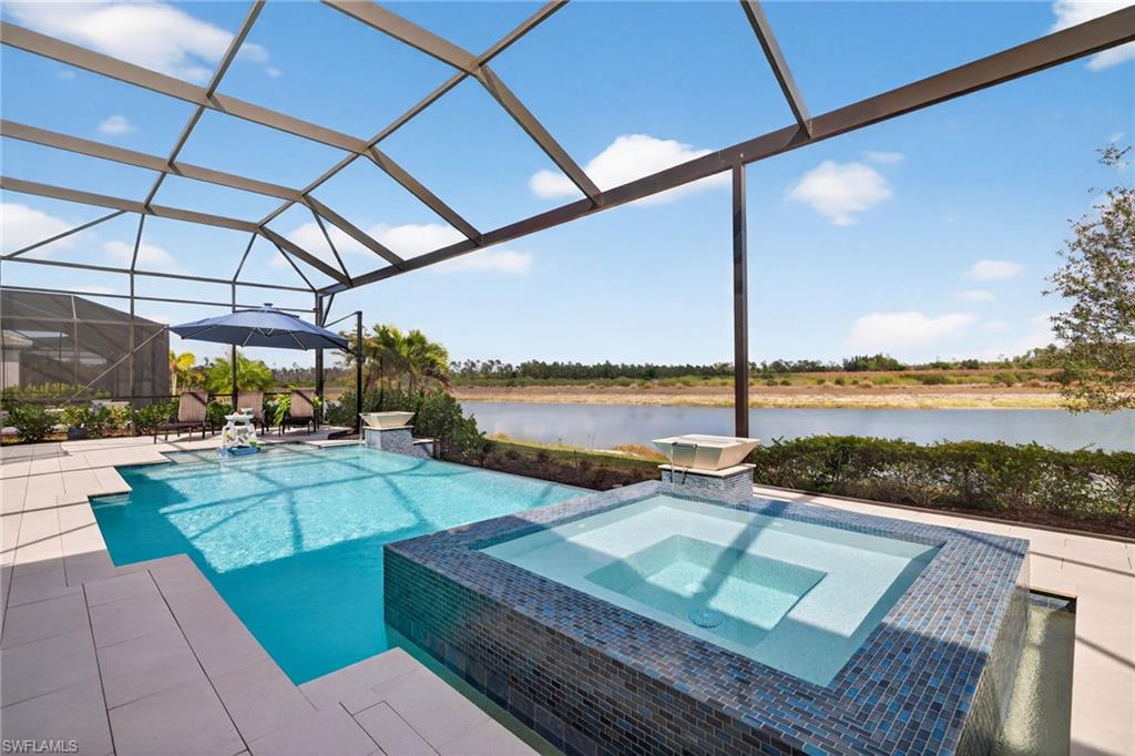 Relaxing pool / spa featuring a water view, a sunroom, a lanai, and a patio