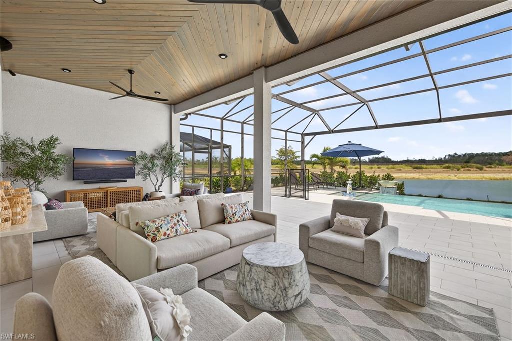 View of patio / terrace with a ceiling fan, a sunroom, an outdoor pool, and an outdoor hangout area