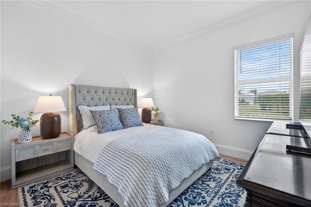 Bedroom with crown molding and wood finished floors