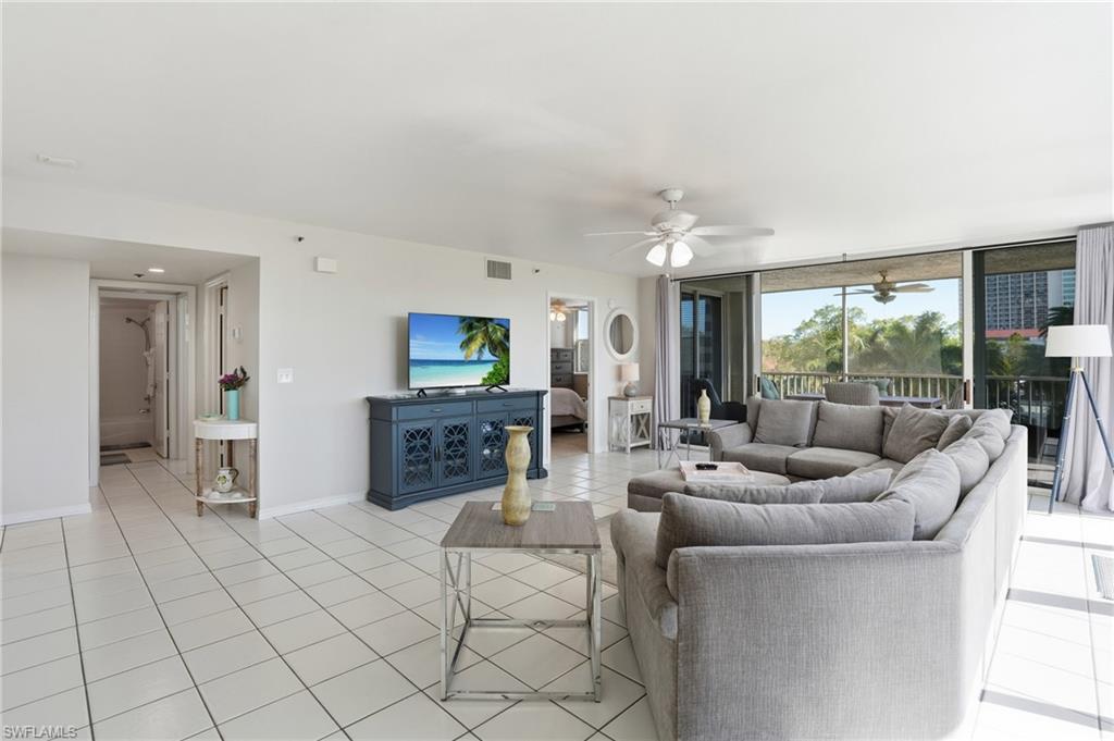 Living room featuring light tile patterned floors and ceiling fan