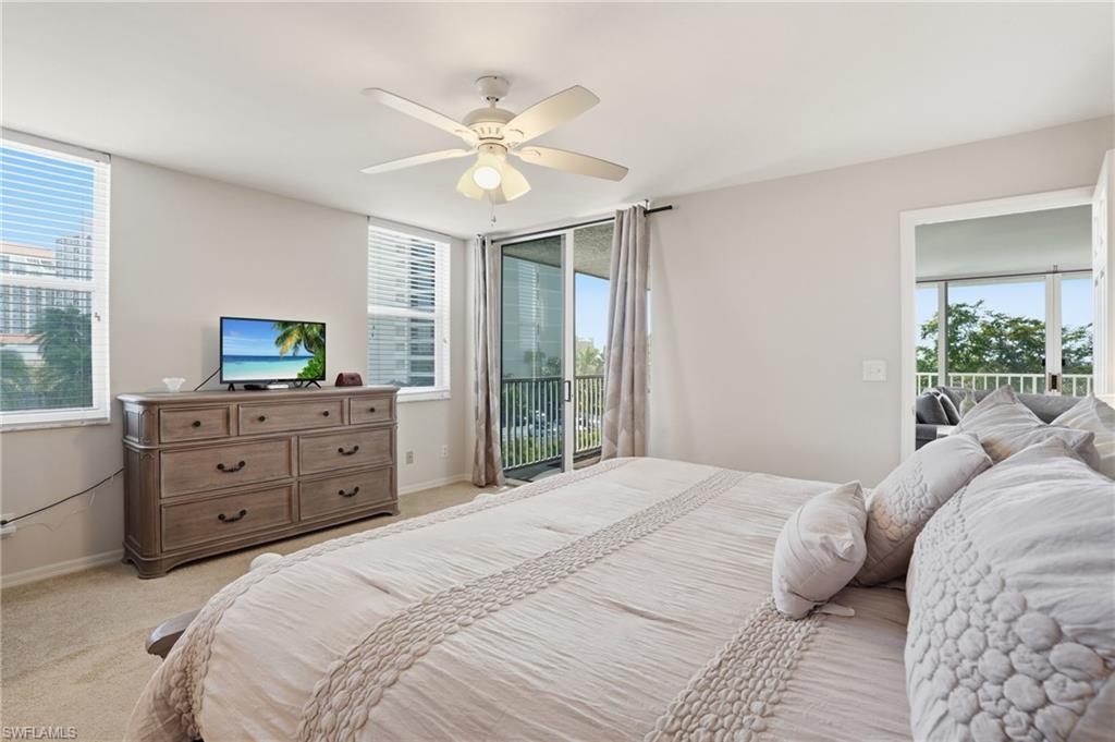 Bedroom with access to outside, multiple windows, and a ceiling fan