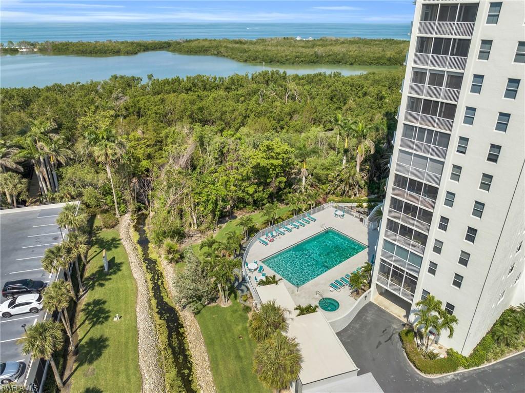 Drone / aerial view of a nearby body of water and a pool