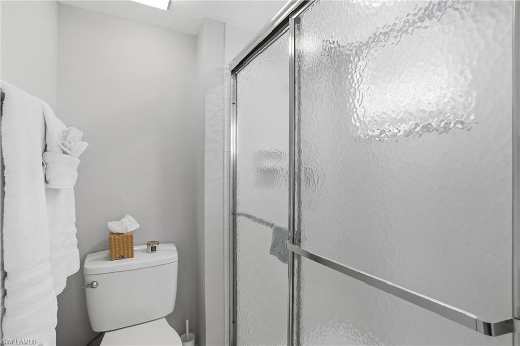 Bathroom with a shower stall and toilet