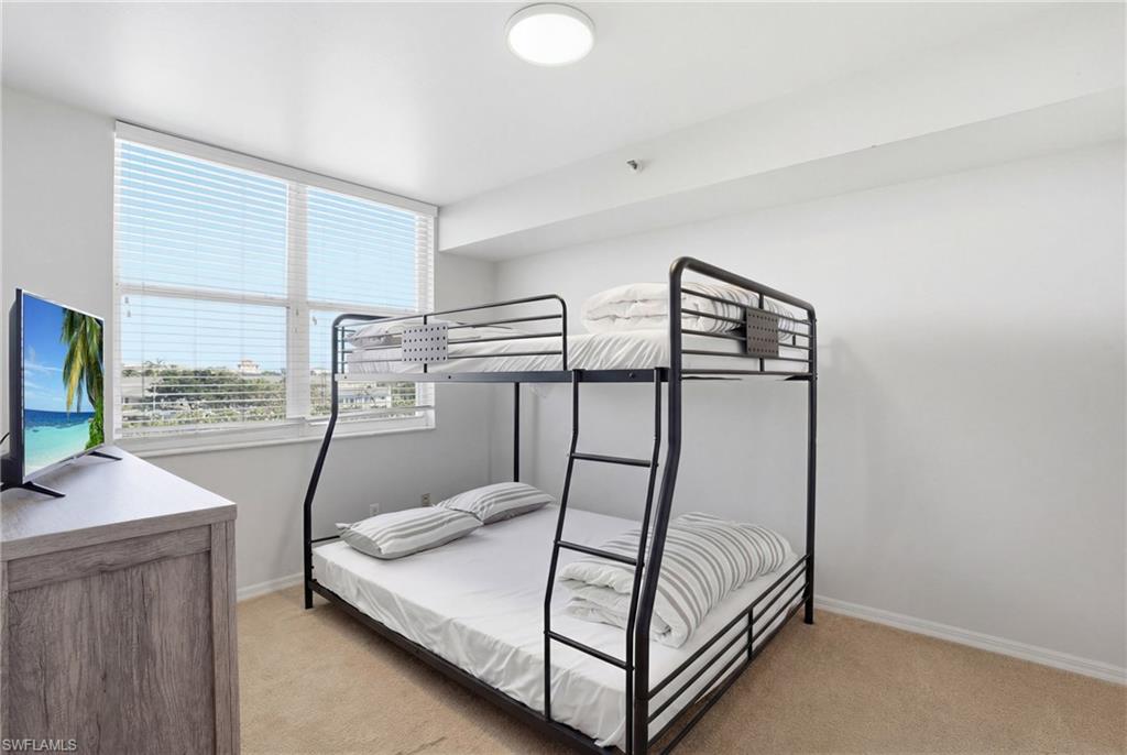 Bedroom with light carpet and baseboards