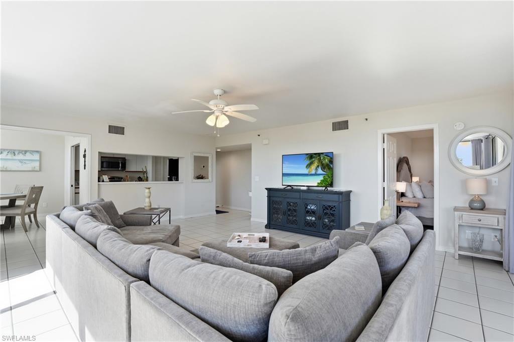 Living room with light tile patterned floors and ceiling fan