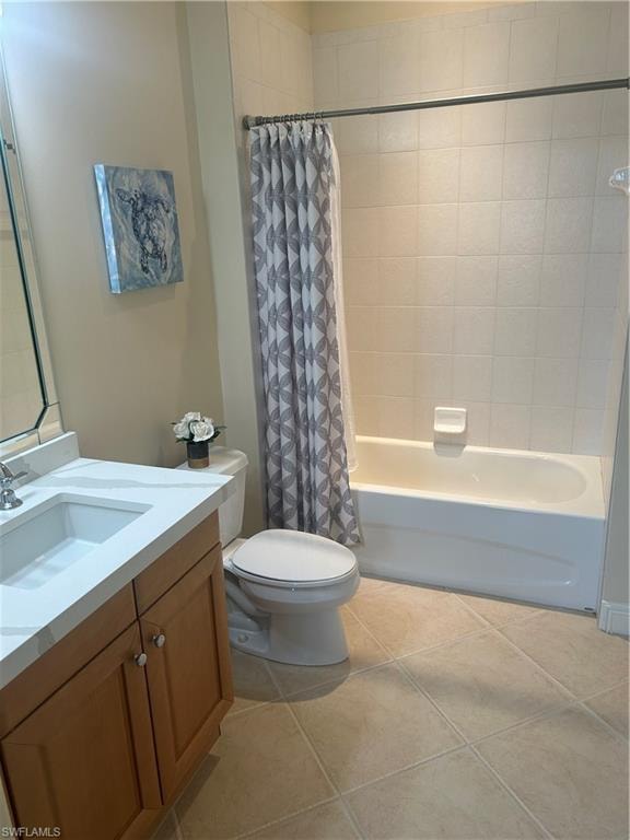 Bathroom featuring shower / bathtub combination with curtain, vanity, and light tile patterned floors