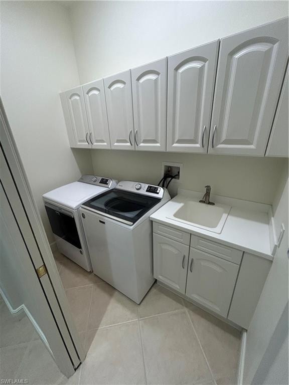 Laundry area featuring cabinet space, washing machine and dryer, and light tile patterned floors
