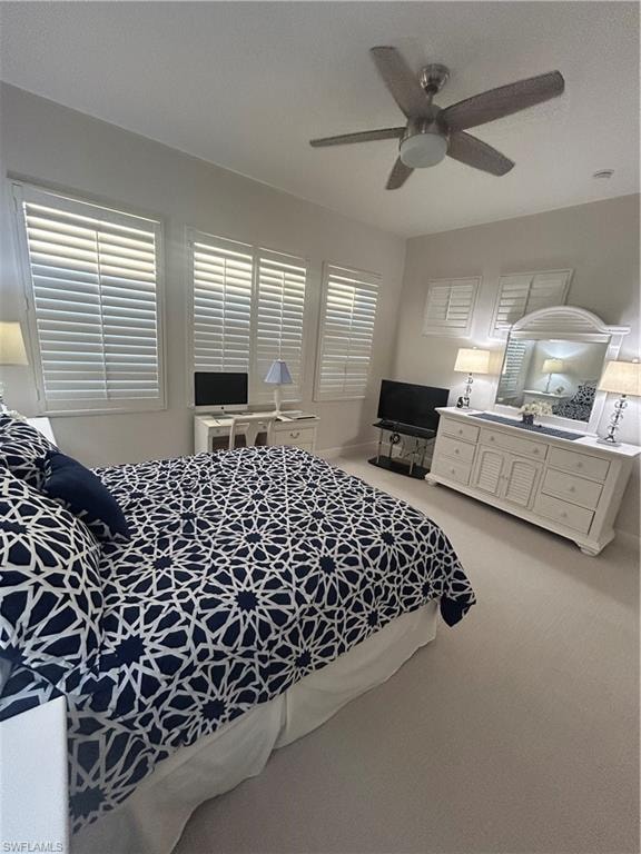 Bedroom featuring light carpet,  a ceiling fan and custom plantation shutters